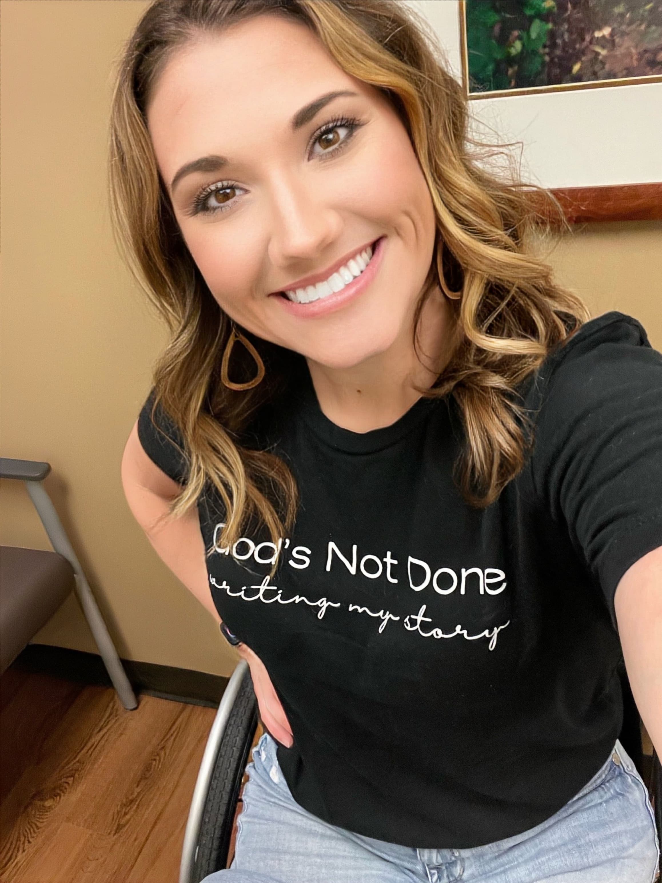 Kristen smiling wearing God's Not Done Writing My Story shirt